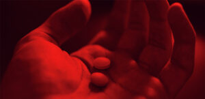 En hand håller i piller, Botad eller förgiftad?