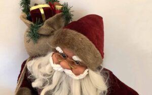 Jultomte med presentpaket på ryggen.