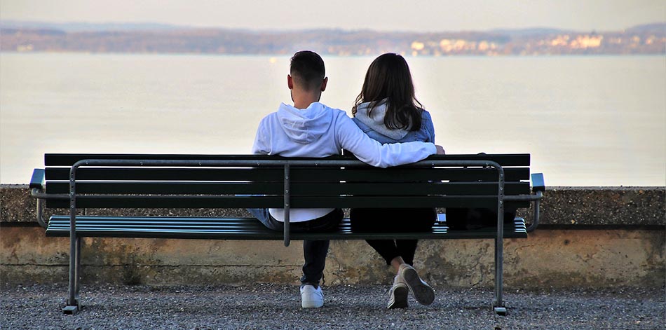 Två ungdomar som sitter på en bänk. Ansiktena mot havet. Fotograf: Pasja1000 från Pixabay