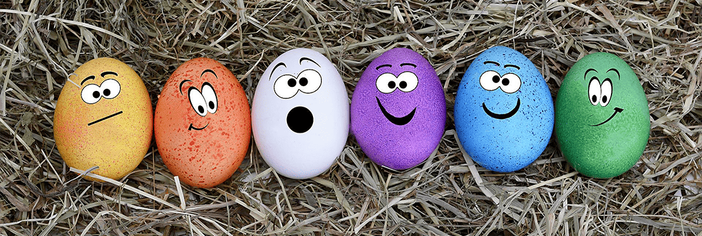 Sex påskägg på i olika färger med olika ansiktsuttryck. De ligger i gräset. Foto: Anncapictures, Pixabay