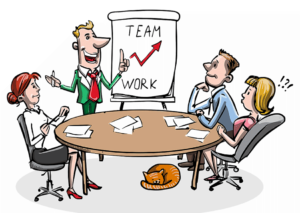 Team-work står skrivet på ett stort block. Kille föreläser. Tre deltagare kring ett runt bord med papper. Liten brun katt ligger under bordet. Foto: Pixabay