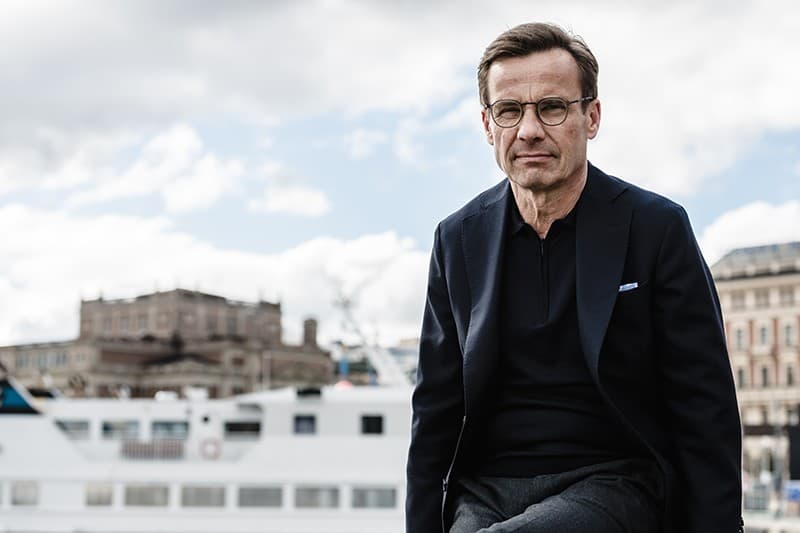 Ulf Kristersson med riksdagshuset i bakgrunden.