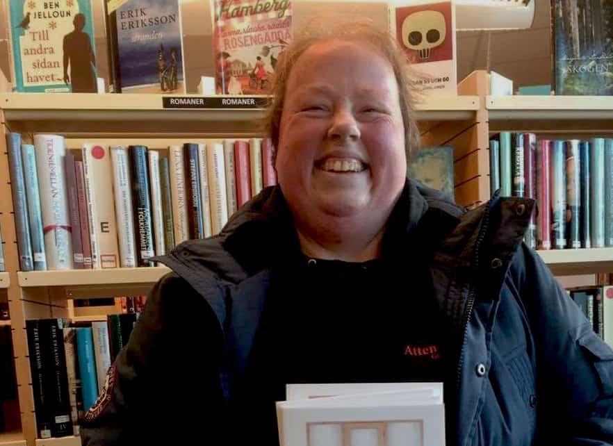 Glad kvinna som håller i en bok.