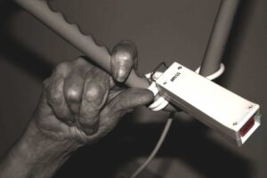 Gammal kvinnohand som greppar efter en nödklocka, antagligen på ett sjukhus. Foto: Geralt från Pixabay