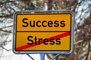 Skylt med texten Success och stress (stress överstruket)