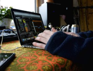Händer som programmerar midi på dator.