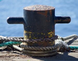 Bild på rep och stolpe vid vatten, för att fästa en båt