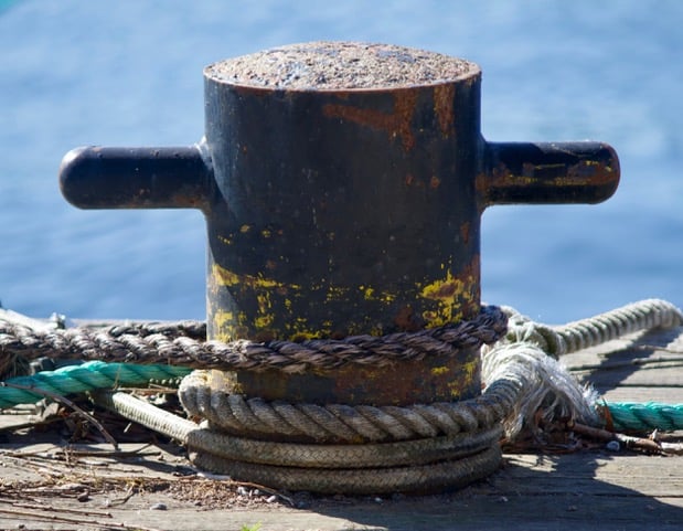 Bild på rep och stolpe vid vatten, för att fästa en båt