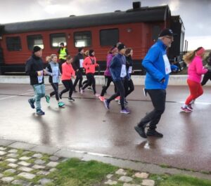 Människor som springer framför röd tågvagn