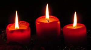 Tre tända röda blockljus på tredje advent. Foto: Hans Braxmeier från Pixabay