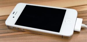 Bild på vit mobil som ligger på ett träbord. Foto: Inspired Images från Pixabay
