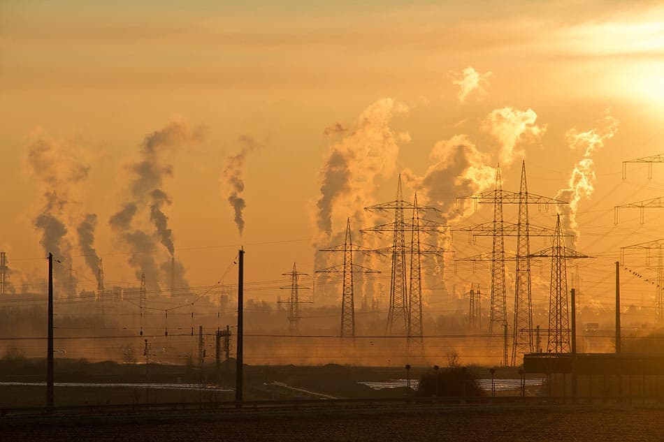 Kolkraftverk som sprutar rök mot gulfärgad himmel. Foto: Pexels-Pixabay