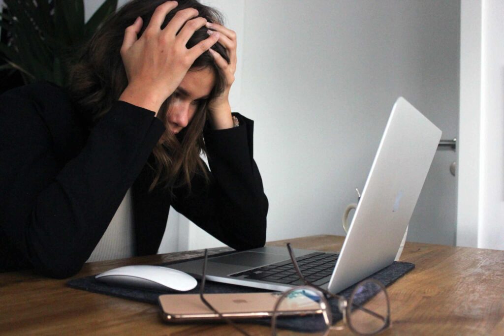 Kvinna som ser frustrerad ut vid laptop