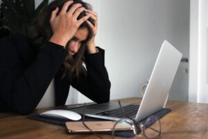 Kvinna som ser frustrerad ut vid laptop