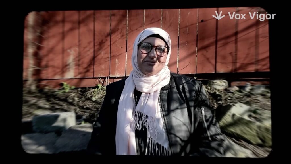 Maria Arisol står framför ett rött plank.