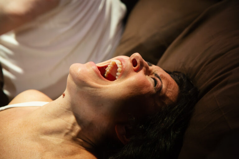 Kvinna som skriker med bakåtfällt huvud