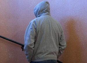 Man med hoodie fotograferad snett bakifrån