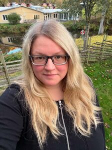 Louise med glasögon och långt blont hår.